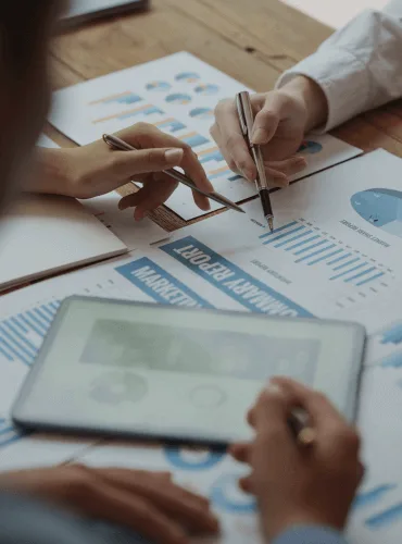Mani che analizzano un report di marketing con grafici e tabelle