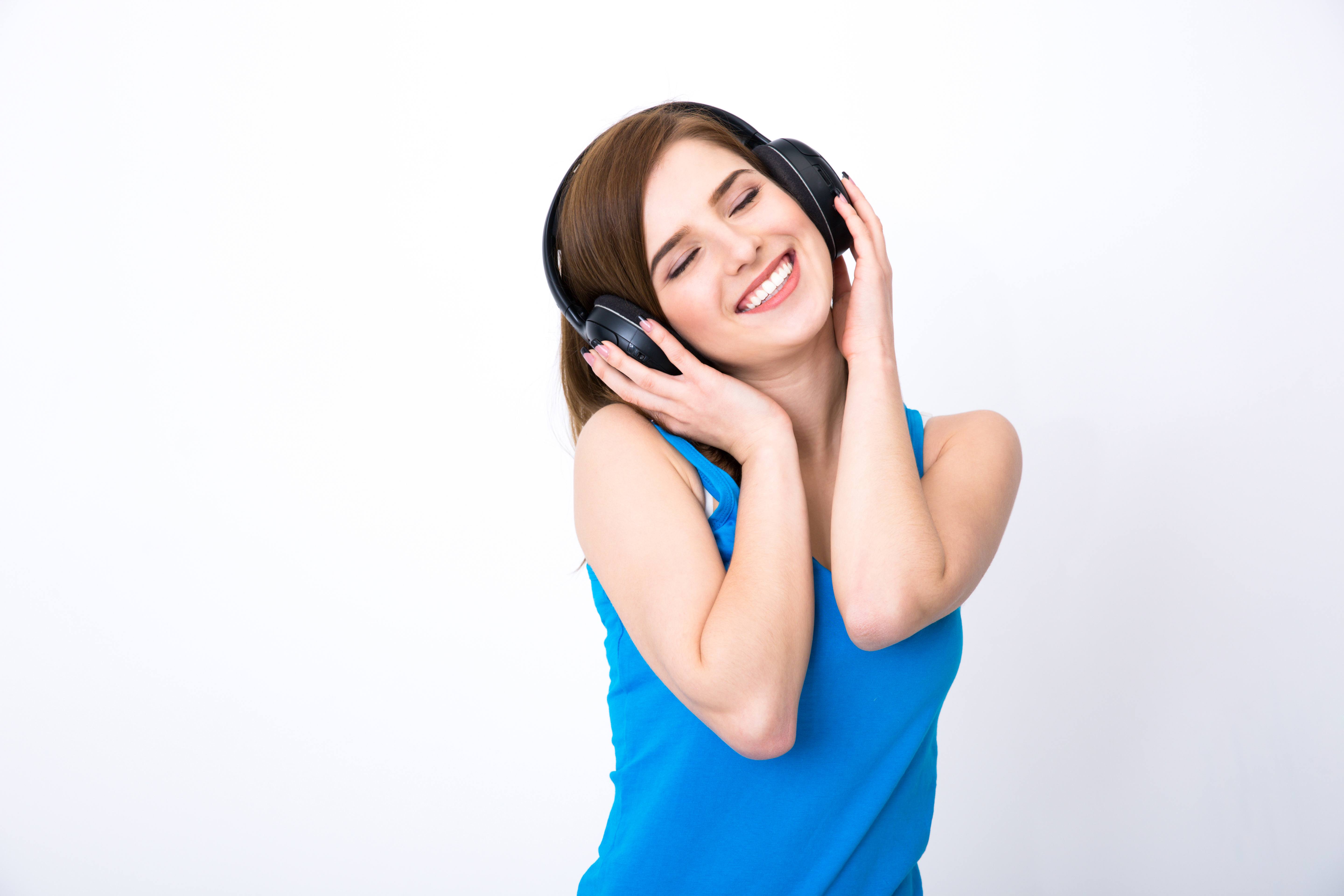 Happy woman with headphones listening music with closed eyes